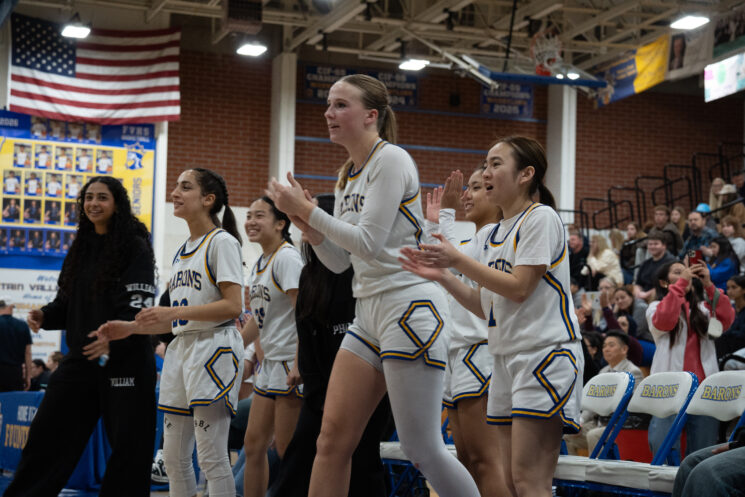 Fountain Valley Barons girl's basketball team cheer on their teammates during a home game.